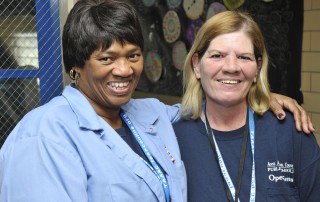 Two female custodians smiling
