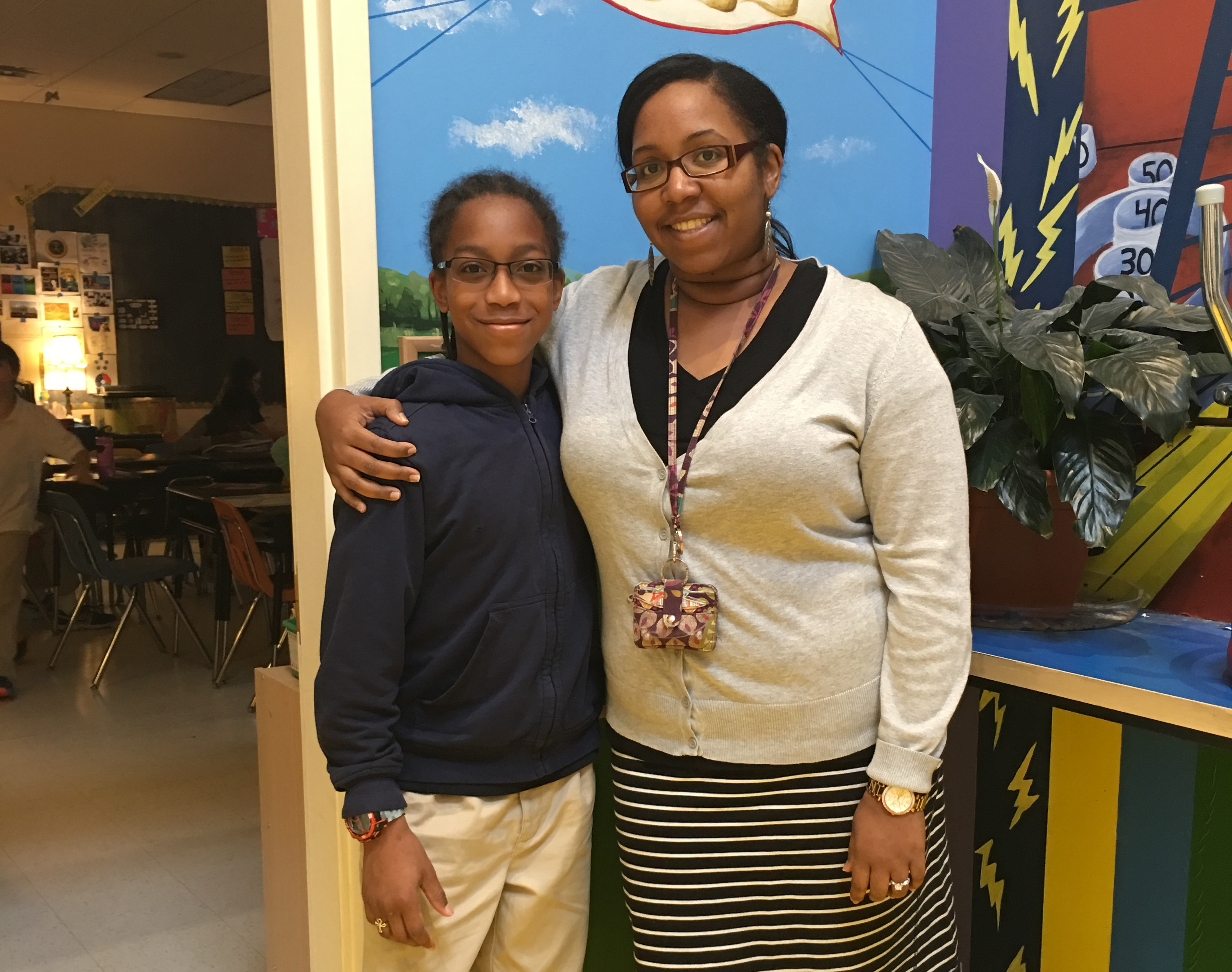 Maxwell standing next to his fifth grade teacher Ms. Tanya