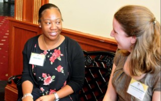 Alexis--Female african american student speaking with female caucasian internship mentor.