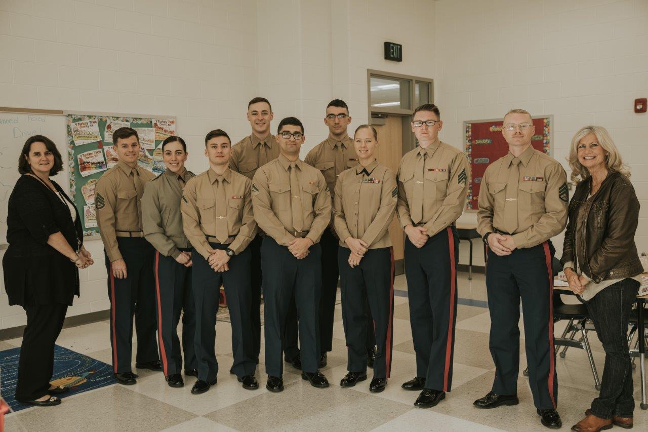 A group of Marines stands smiling at the camera.