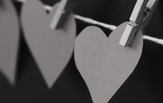 Paper hearts held on a string by clothespins