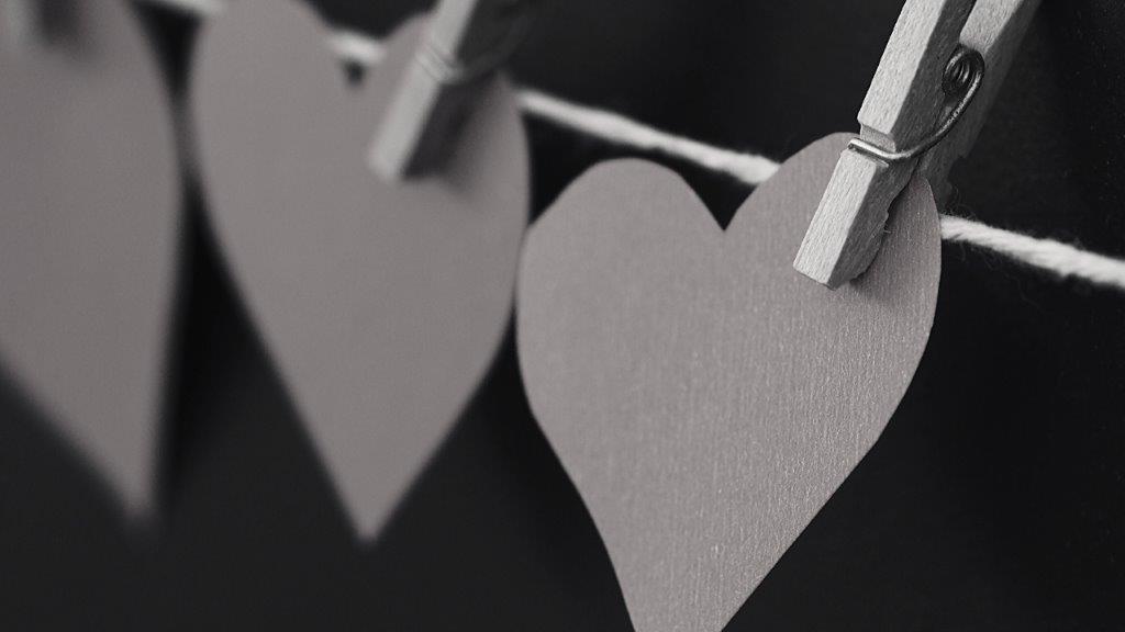 Paper hearts held on a string by clothespins