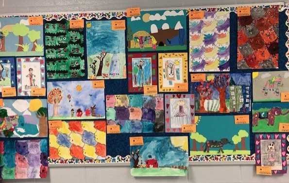 Photo of elementary students' artwork covering a bulletin board.