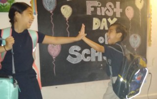 Two children giving a high five on the first day of school