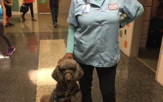 Sarah Moulden, the custodian at Southgate Elementary, standing with a service dog.